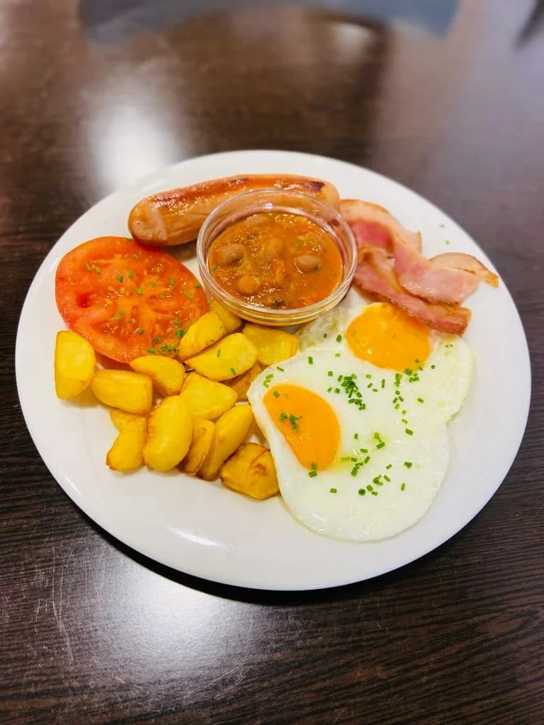Desayuno Inglés con huevos fritos, bacon, salchicha, patatas, tomate y alubias en La Nonna Brunch, en el centro de Figueres