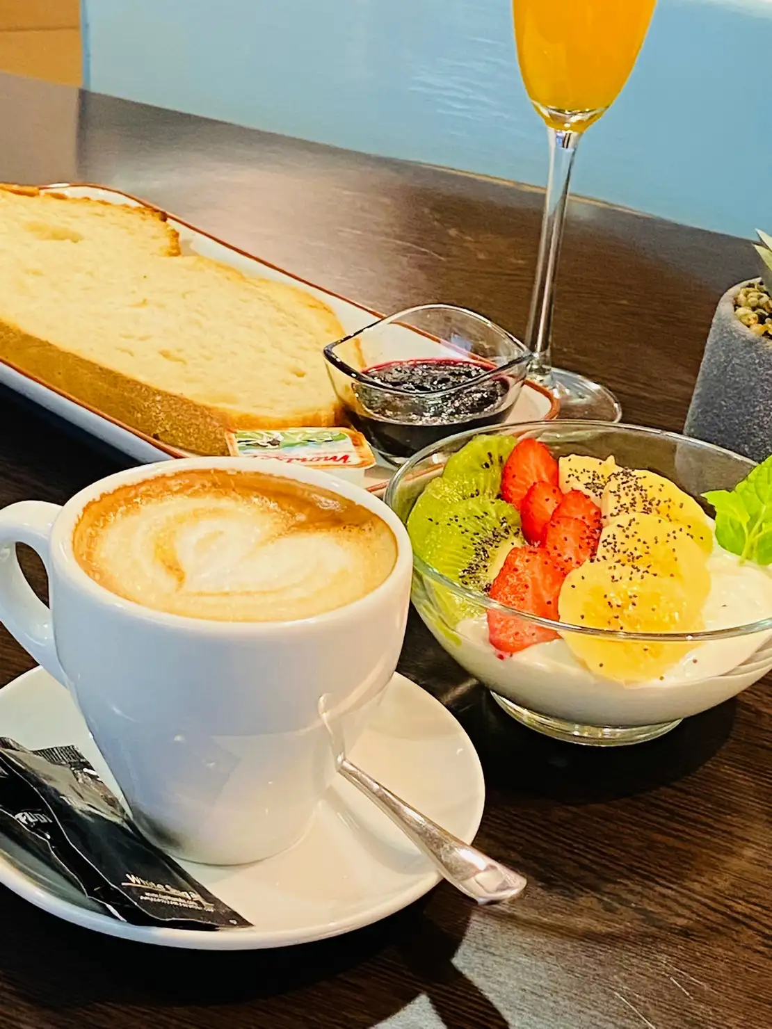 Desayuno variado en La Nonna Brunch en Figueres con café con leche, tostada, mermelada y bowl de yogur con fruta fresca