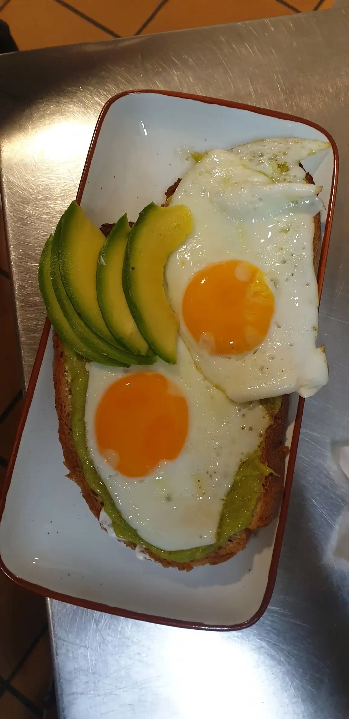 Tosta Aguacate & Bacon con dos huevos fritos y láminas de aguacate en La Nonna Brunch, restaurante de brunch en Figueres