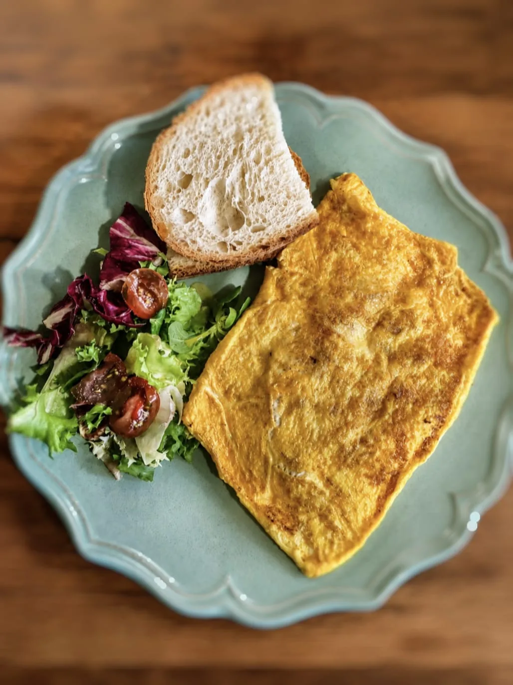 Omelette al gusto con pan rústico y ensalada verde en un plato de La Nonna Brunch, en Figueres