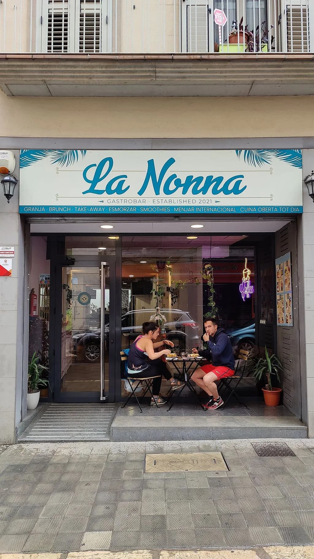 Vaso alto de zumo de zanahoria recién hecho sobre barra de madera en La Nonna Brunch, en el centro de Figueres